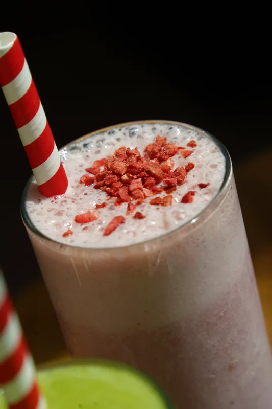 Creamy berry smoothie with a striped straw