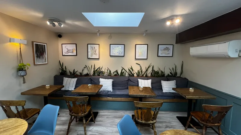 Booth seating area with artwork and plants