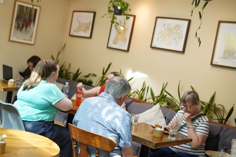 Guests enjoying the bright plant-filled cafe